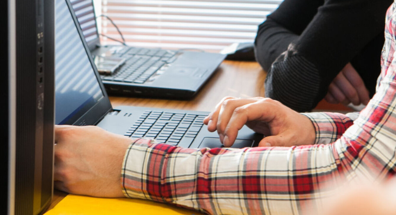 Photo d'illustration. Une personne utilise le clavier d'un ordinateur portable. Un zoom est réalisé sur ses mains.